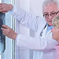 Cancro al polmone: il medico mostra alla sua paziente la radiografia al torace