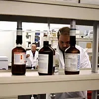 Panoramica di laboratorio di tossicologia con operatori al lavoro e flaconi di reattvi