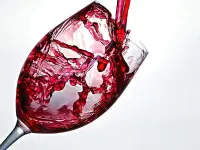 La fotografia coglie il momento in cui il vino viene versato nel calice.