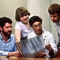 quattro scienziati al lavoro sull'elettroforesi del DNA nei laboatori NCI nel 1987